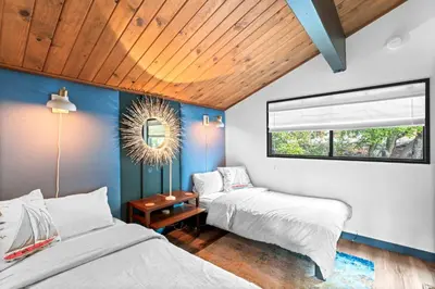 two beds in a room with blue walls at BlackOak Hideaway in Lake Arrowhead