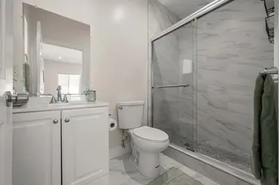a white bathroom with a toilet and a shower at Stay on Hart in Los Angeles