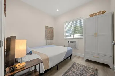 a bedroom with a bed and a table and a window at Stay on Hart in Los Angeles