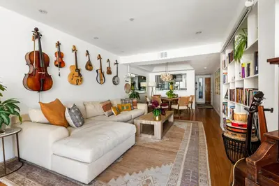 a living room with a white couch and violins on the wall at Oceanfront Artists Retreat Santa Monica Luxury in Los Angeles