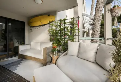 a living room with a couch and a surfboard on the wall at Oceanfront Artists Retreat Santa Monica Luxury in Los Angeles