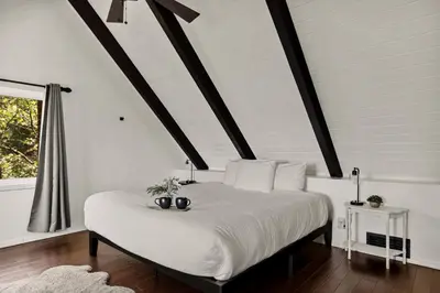 a bedroom with a large white bed with a window at The Mountain Sanctuary in Lake Arrowhead