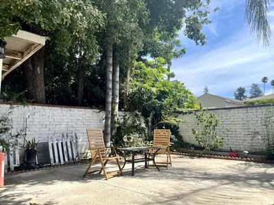 a patio with two chairs and a table and a fence at Pasadena Quiet Gem with Fiber Internet WiFi and Workspace in Pasadena