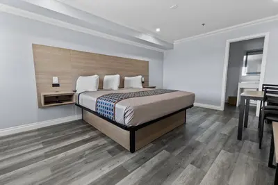a bedroom with a bed and a table and a desk at Downey Inn in Downey