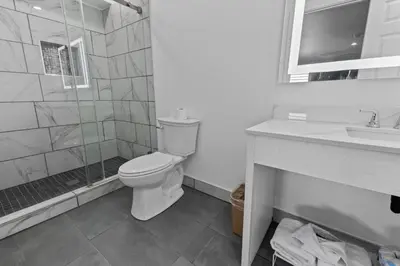 a bathroom with a toilet and a shower and a sink at Downey Inn in Downey