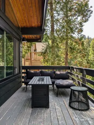 a patio with a couch and a table and chairs at Fam & Pet Friendly Chalet w AC & BBQ - Top Rated in Crestline