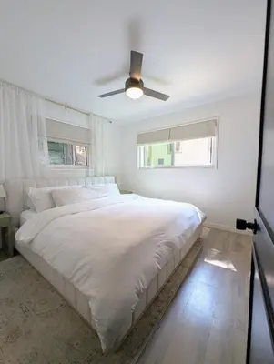 a white bedroom with a bed and a ceiling fan at Fam & Pet Friendly Chalet w AC & BBQ - Top Rated in Crestline