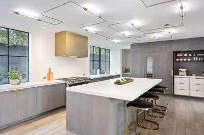 a large kitchen with a large white counter and stools at The Colony Reserve by Stay Awhile Villas in Malibu Beach