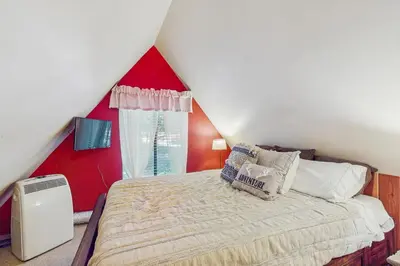 a bedroom with a large bed with a red wall at Couples Retreat Near Lake Arrowhead and Hiking! in Lake Arrowhead