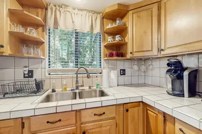 a kitchen with wooden cabinets and a sink at Couples Retreat Near Lake Arrowhead and Hiking! in Lake Arrowhead
