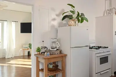 a kitchen with a white refrigerator and a table at At Hermosa Ave and Pier Ave- C in Hermosa Beach