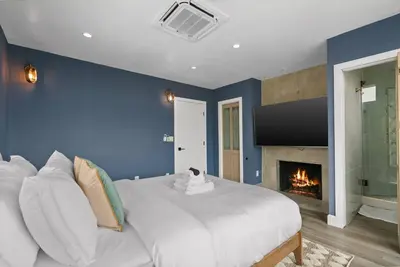 a bedroom with a large bed and a fireplace at New Listing Palisades Villa by Colby & Conrad in Los Angeles