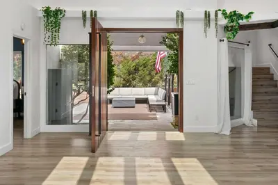 an open door into a living room with a couch at New Listing Palisades Villa by Colby & Conrad in Los Angeles