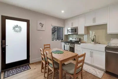a kitchen with a wooden table and chairs in a kitchen at Feel At Home At A One Bedroom Apt 1 Block From The Beach in Hermosa Beach