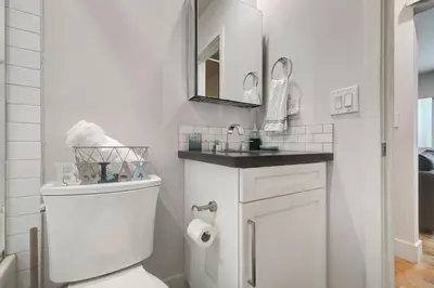 a white bathroom with a toilet and a mirror at Feel At Home At A One Bedroom Apt 1 Block From The Beach in Hermosa Beach