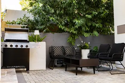 a patio with a stove and chairs and a tree at Grand 4-Bedroom - Brand New - Free parking and Patio in Los Angeles