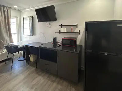 a kitchen with a desk with a microwave and a television at Studio 6 Suites Buena Park CA Anahiem Near Maingate Knotts in Buena Park