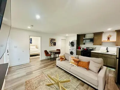 a living room with a couch and a kitchen at Modern LA Guest House in Los Angeles
