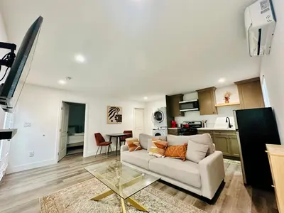 a living room with a couch and a kitchen at Modern LA Guest House in Los Angeles