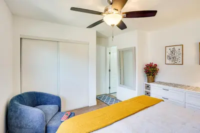a bedroom with a blue chair and a ceiling fan at Explore SoCal! Cozy Retreat Near Disney and Beaches in Westminster