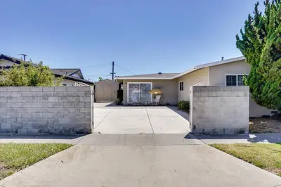 a house with a fence and a driveway at Explore SoCal! Cozy Retreat Near Disney and Beaches in Westminster
