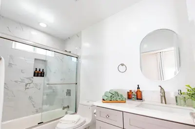a bathroom with a shower and a toilet and a mirror at Luxury House 3-Level 4-bedroom, Free Parking and Patio in Los Angeles