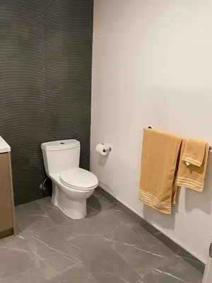 a bathroom with a toilet and towels on the wall at Luxury 1 Bedroom vacation Home in Downtown LA in Los Angeles