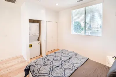 a bedroom with a bed and a refrigerator and a window at Modern 1-Bedromm Loft In Hollywood With Viwe of Hollywood Sign in Los Angeles