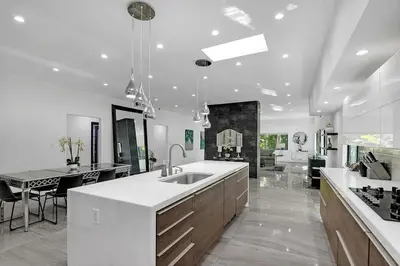 a large white kitchen with a sink and a table at Mansfield Modern in Los Angeles