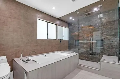 a bathroom with a tub and a shower and a toilet at Mansfield Modern in Los Angeles