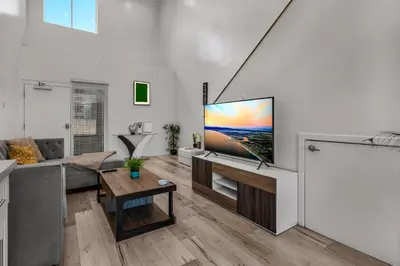 a living room with a flat screen tv on a wall at Loft-Style 1-Bedroom Apartment with Balcony & Private Parking in Hollywood in Los Angeles
