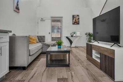 a living room with a couch and a tv at Loft-Style 1-Bedroom Apartment with Balcony & Private Parking in Hollywood in Los Angeles