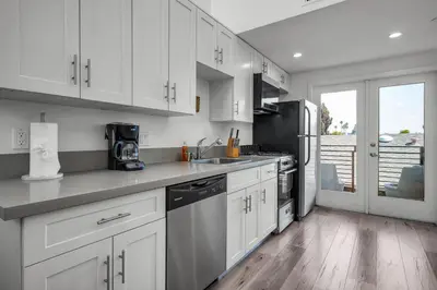 a kitchen with white cabinets and a counter top at Lux Hollywood Loft 1BR with Balcony & Private Parking 10 Min to Downtown LA in Los Angeles