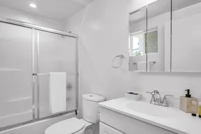 a white bathroom with a toilet and a shower at Lux Hollywood Loft 1BR with Balcony & Private Parking 10 Min to Downtown LA in Los Angeles