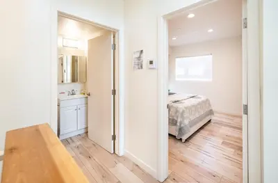 a bedroom with a bed and a door leading to a bathroom at Chic Hollywood Koreatown 3Bedroom Loft 3 Level 2 Bathrooms Perfect for Groups up to 10 in Los Angeles