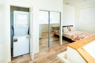 a small bedroom with a bed and a refrigerator at Chic Hollywood Koreatown 3Bedroom Loft 3 Level 2 Bathrooms Perfect for Groups up to 10 in Los Angeles