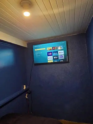 a flat screen tv hanging on a blue wall at Entire Front House in Los Angeles in Los Angeles