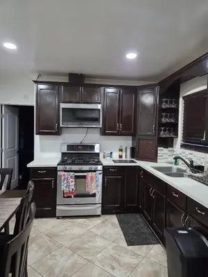 a kitchen with wooden cabinets and a stove top oven at Entire Front House in Los Angeles in Los Angeles
