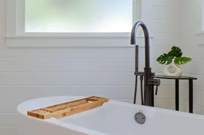 a bath tub with a sink with a faucet at Spacious 4BR Games Workspace Outdoor Fun in Los Angeles