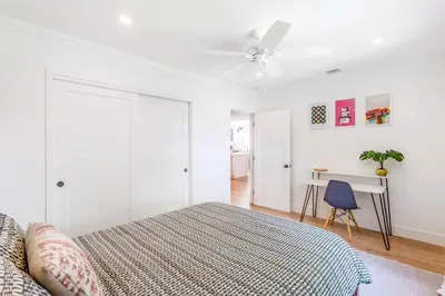 a white bedroom with a bed and a ceiling fan at Spacious 4BR Games Workspace Outdoor Fun in Los Angeles