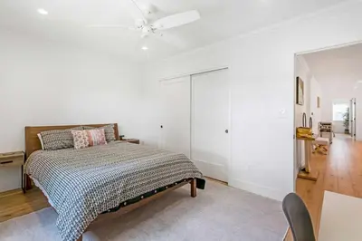 a white bedroom with a bed and a ceiling fan at Spacious 4BR Games Workspace Outdoor Fun in Los Angeles