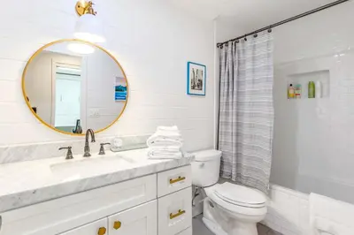 a white bathroom with a toilet and a mirror at Spacious 4BR Games Workspace Outdoor Fun in Los Angeles