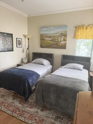 a bedroom with two beds and a painting on the wall at 1140 Alta Loma in Los Angeles