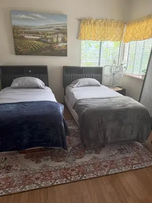 a bedroom with two beds and a rug at 1140 Alta Loma in Los Angeles