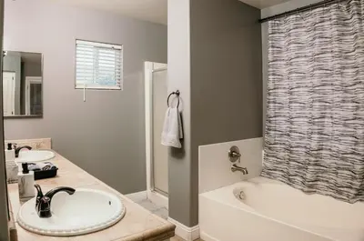 a bathroom with a tub and a sink and a shower at Stunning Home with Pool, Game Room and Firepit in Bakersfield