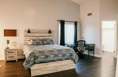 a bedroom with a bed and a desk and a chair at Stunning Home with Pool, Game Room and Firepit in Bakersfield