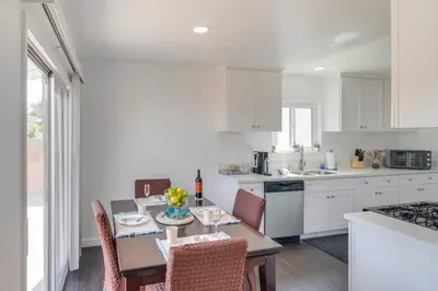 a kitchen with white cabinets and a table with chairs at HOV Lux Whitehouse Lakeview Terrace