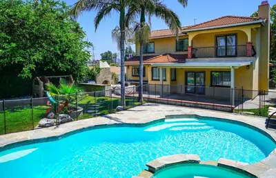 a swimming pool in front of a house at Gorgeous Villa with Private Heated Pool in Garnsey