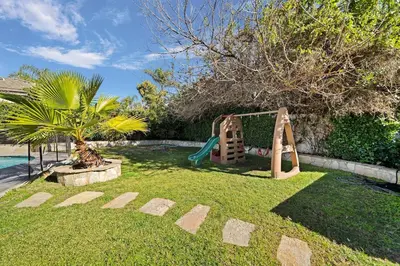 a playground in a yard with a swing at Gorgeous Villa with Private Heated Pool in Garnsey