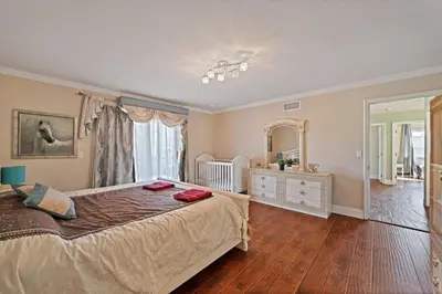 a bedroom with a large bed and a large mirror at Gorgeous Villa with Private Heated Pool in Garnsey